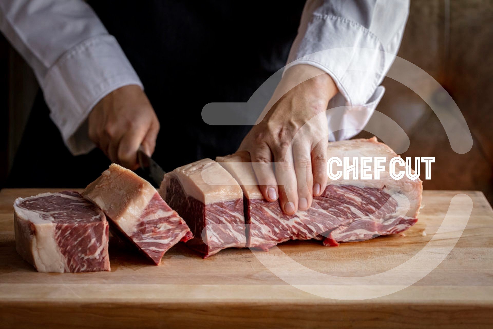 A Chef Cut butcher hand-cutting a prime rib on the butcher block