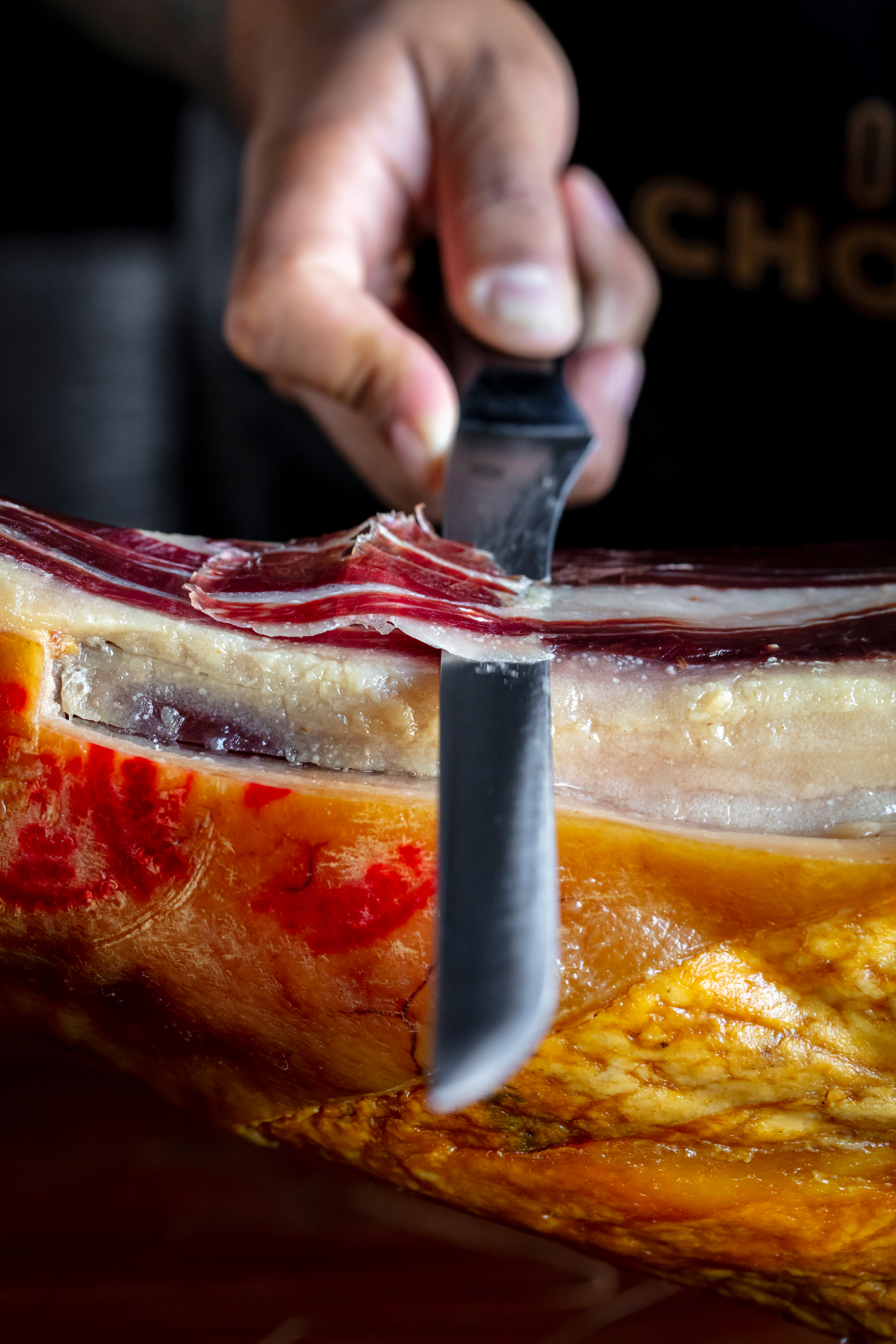 Hand-carving a cured jamon at the counter